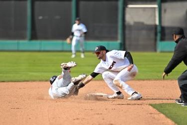 Pacific baseball player tags a runner out at second base.